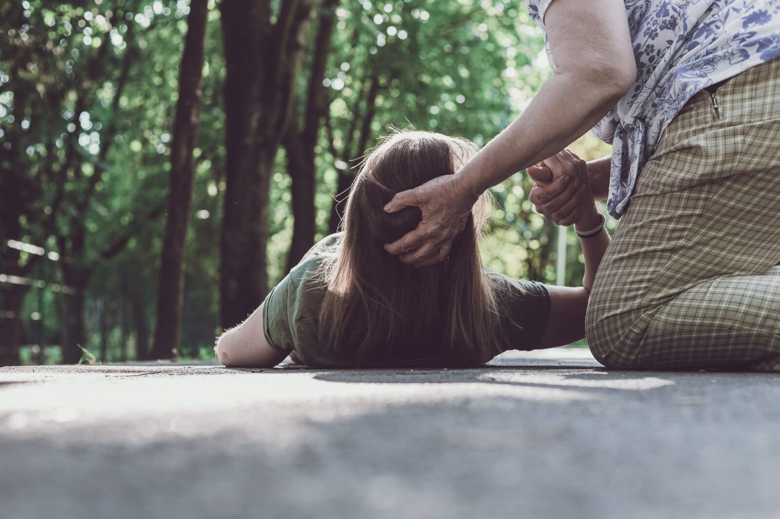 a girl and a boy holding a house cutout sitting in the grass on a